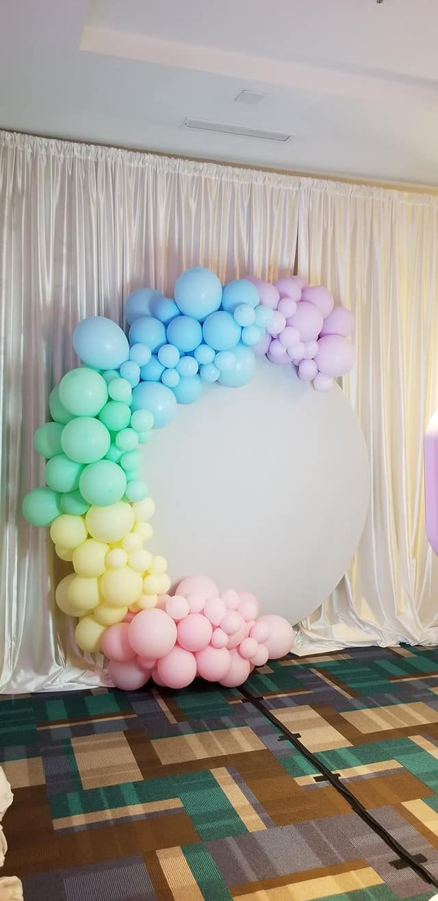 A room with a rainbow of balloons on the wall.
