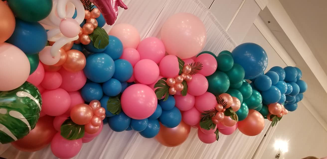 A bunch of balloons are hanging on a wall.