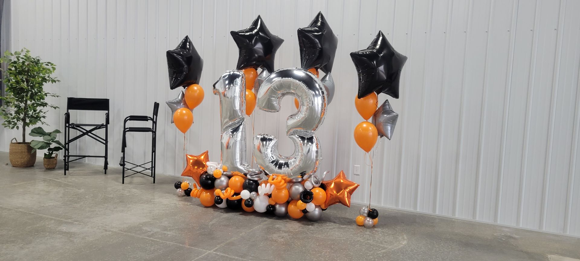 A bunch of balloons are sitting on the floor in front of a wall.