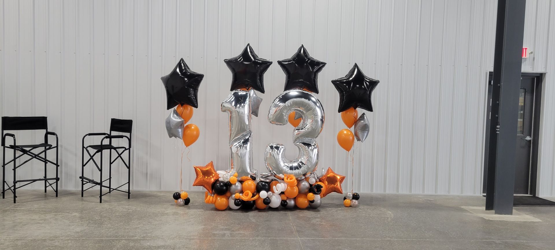 A bunch of balloons are sitting on the floor in a room. Balloon Marquee