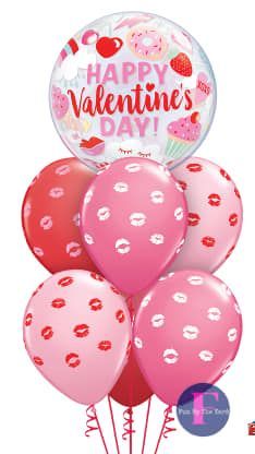 A bunch of pink and red balloons with kisses on them for valentine 's day.
