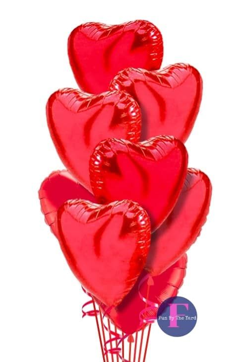 A bunch of red heart shaped balloons stacked on top of each other