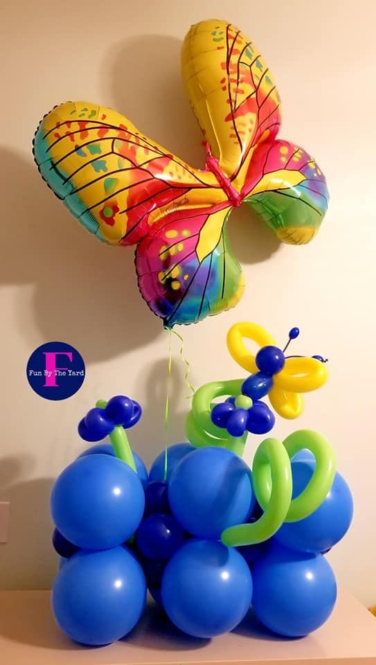 A bunch of blue balloons with a butterfly and flowers made out of them