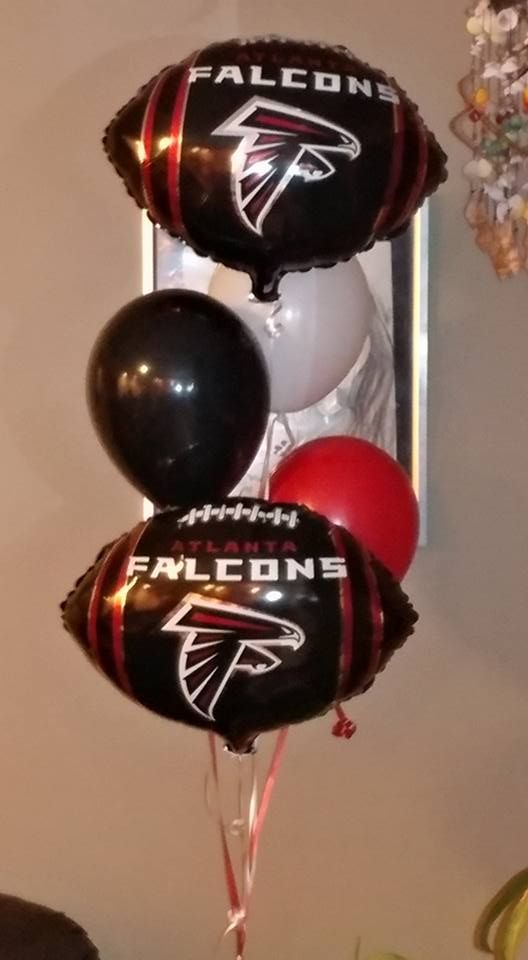 A bunch of falcons balloons are sitting on a table