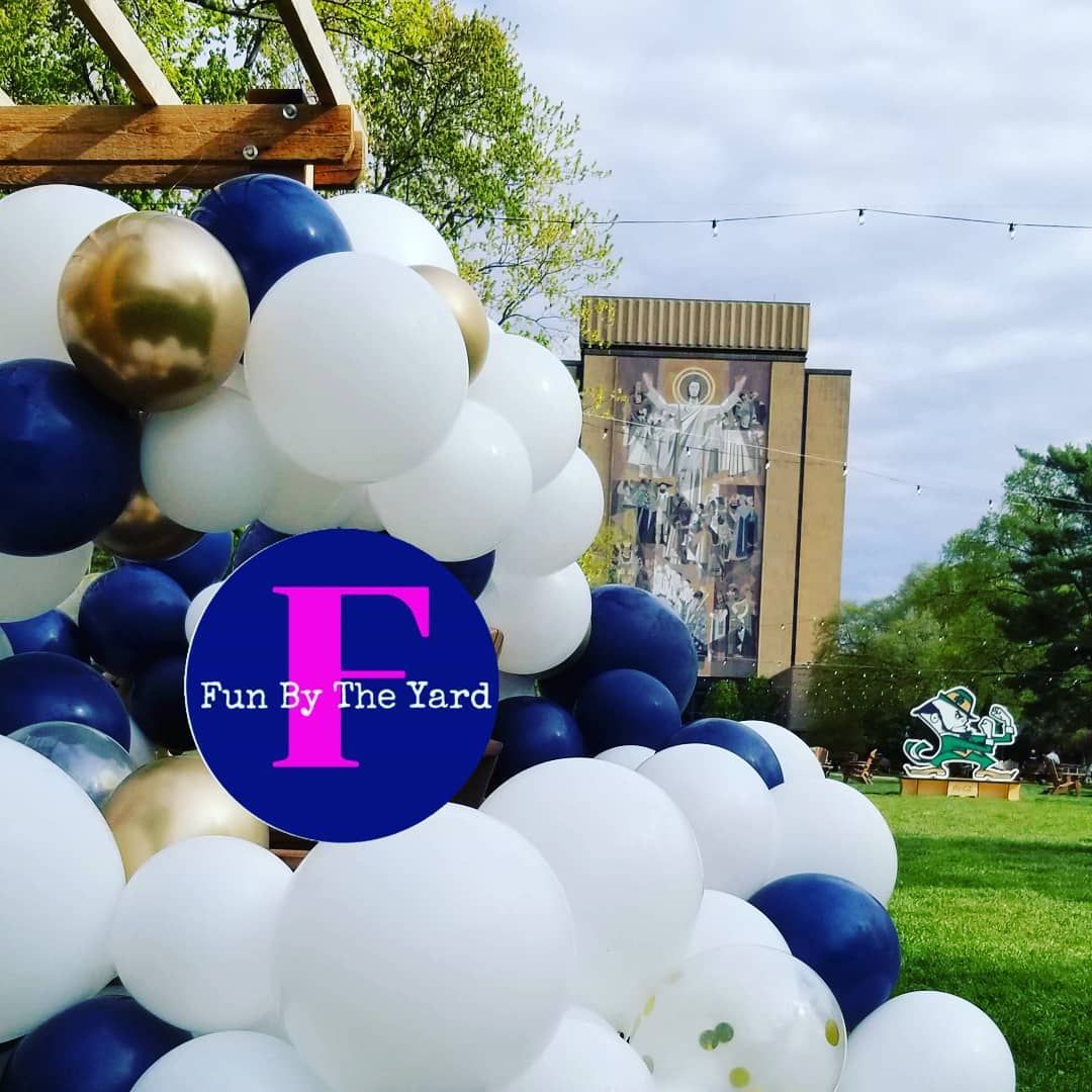 a bunch of balloons with a sign that says fun by the yard