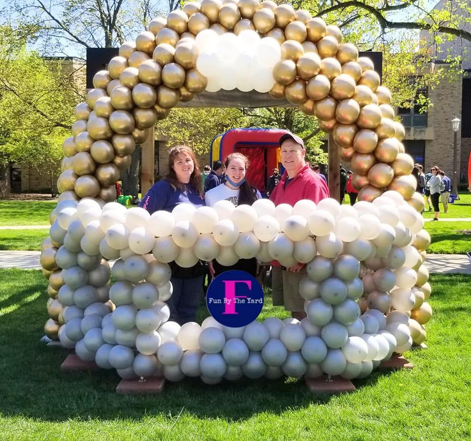 Fun By The Yard crew standing inside a Notre Dame football helmet sculpture make of balloons