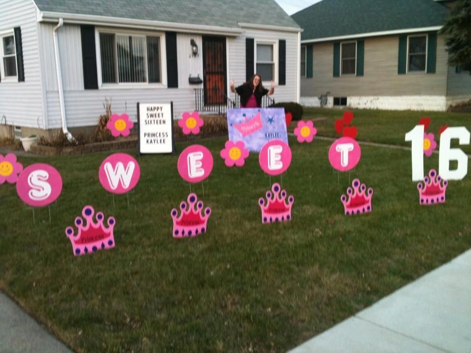 A woman stands in front of a sign that says sweet 16