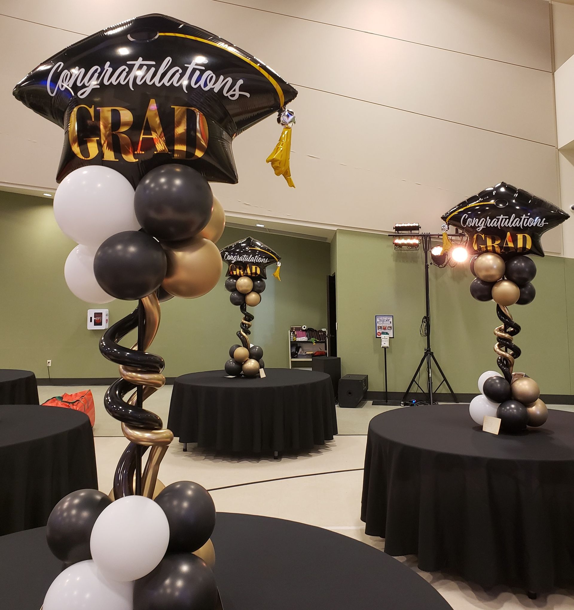 A room filled with tables and balloons and a balloon that says congratulations grad