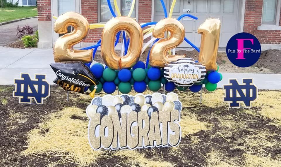 A congratulations sign with balloons and a graduation cap.