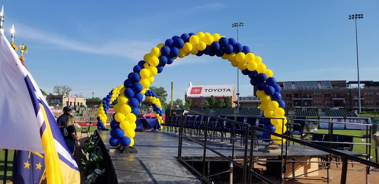A blue and yellow balloon arch is sitting on top of a stage.