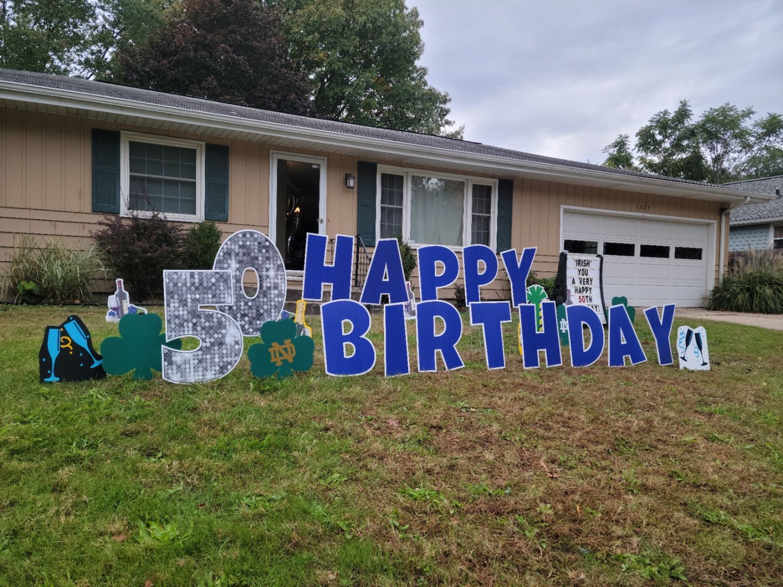 A happy birthday sign is in front of a house.