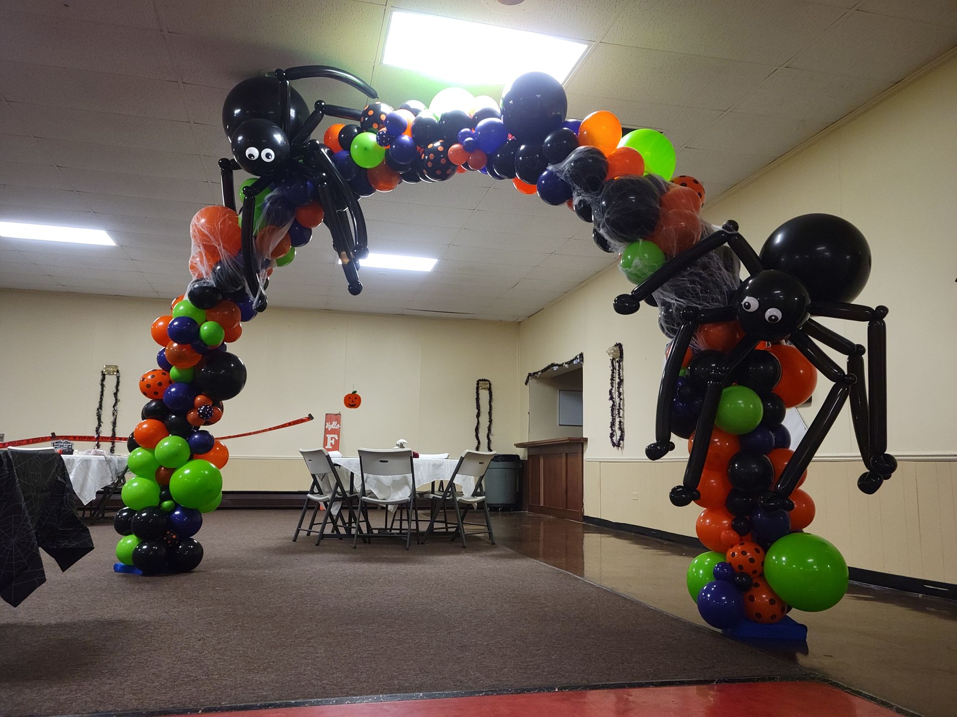 A room decorated with balloons and spiders for halloween. Organic balloon arch.