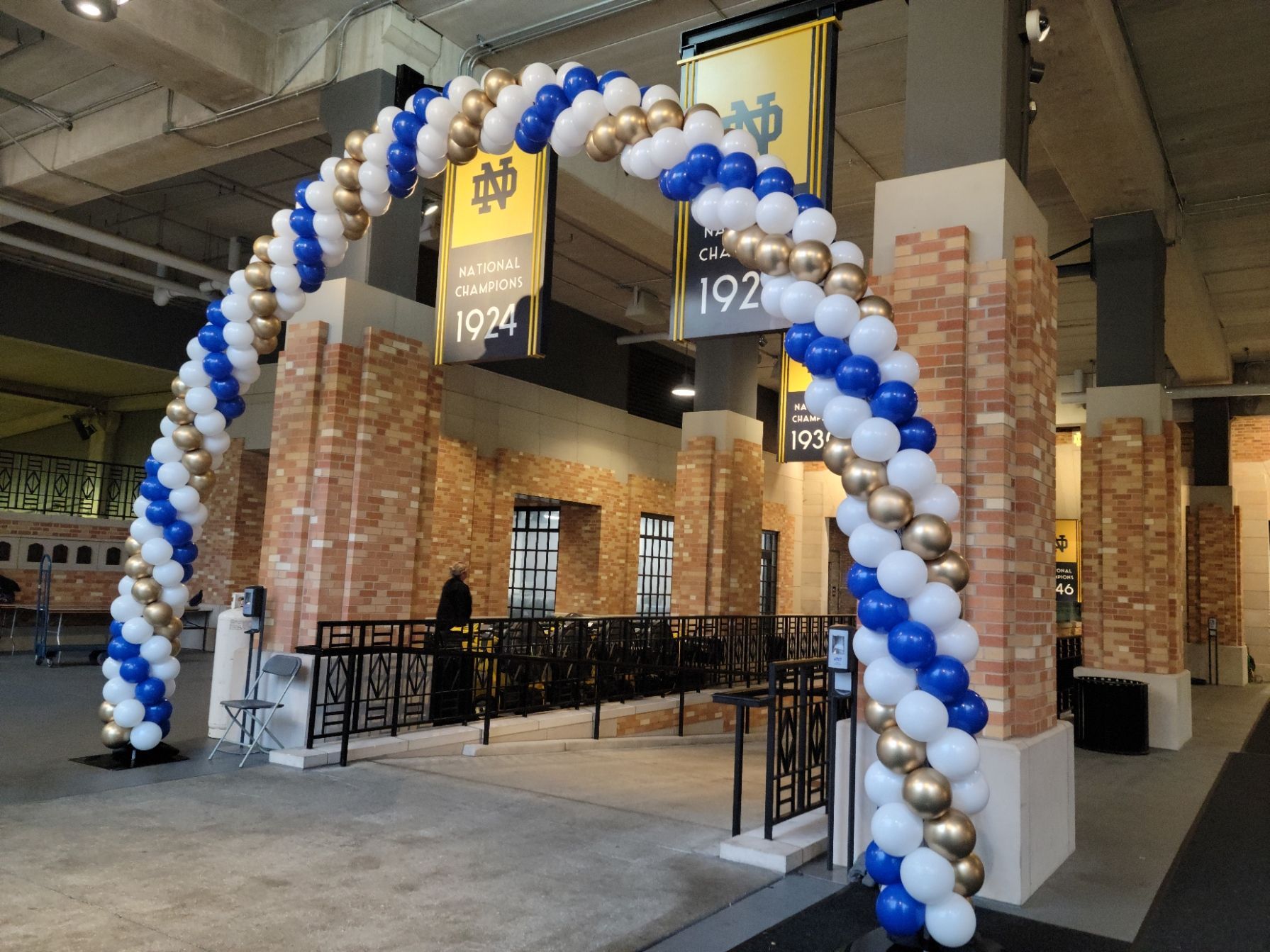 A large arch made of blue and gold balloons inside Notre Dame Stadium