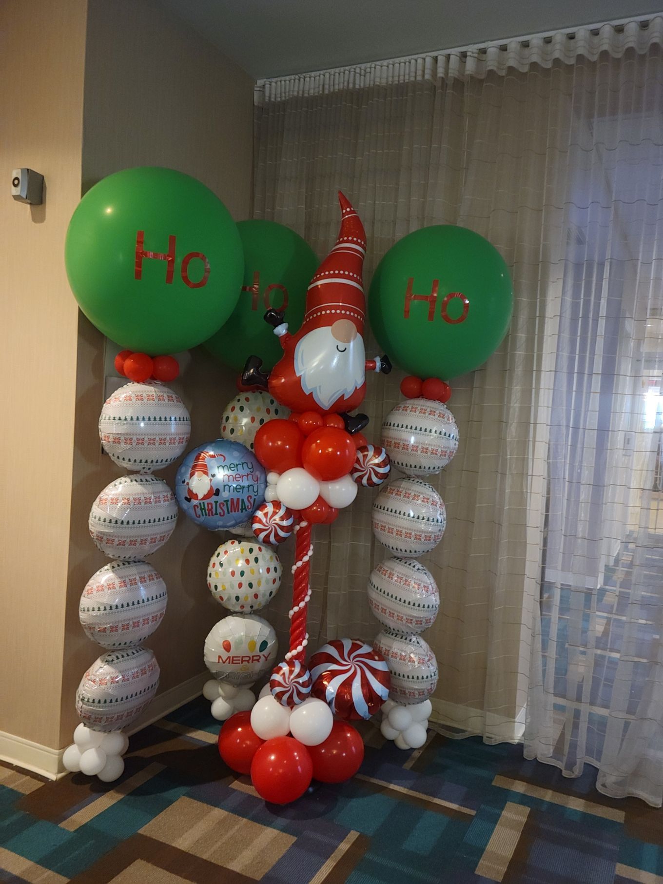 A christmas decoration made of balloons and candy canes in a room.
