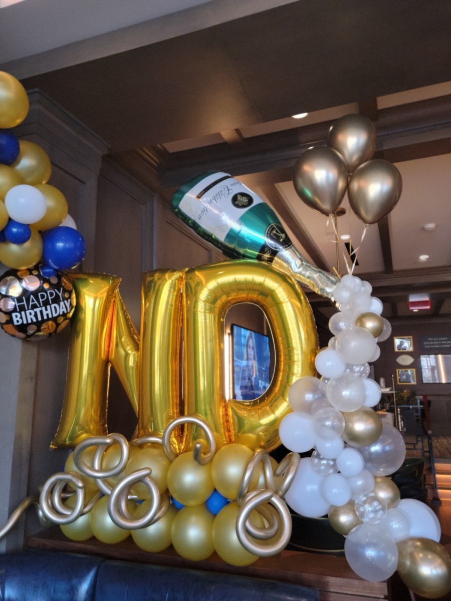 A bunch of birthday balloons including one that says ND. Balloon marquee with champagne