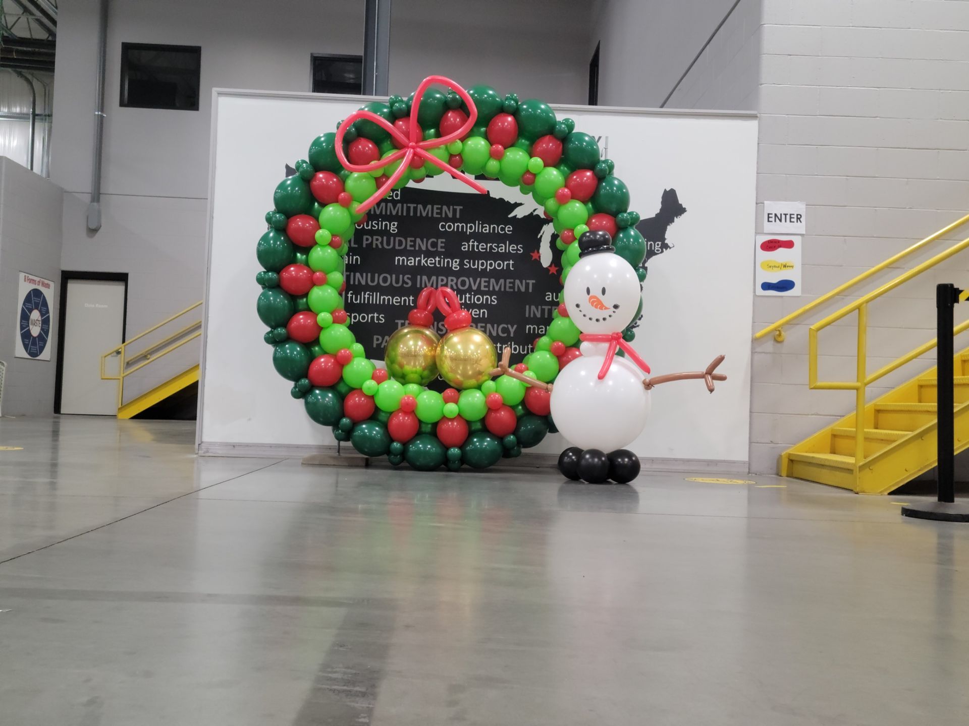 A large christmas wreath with a snowman made out of balloons