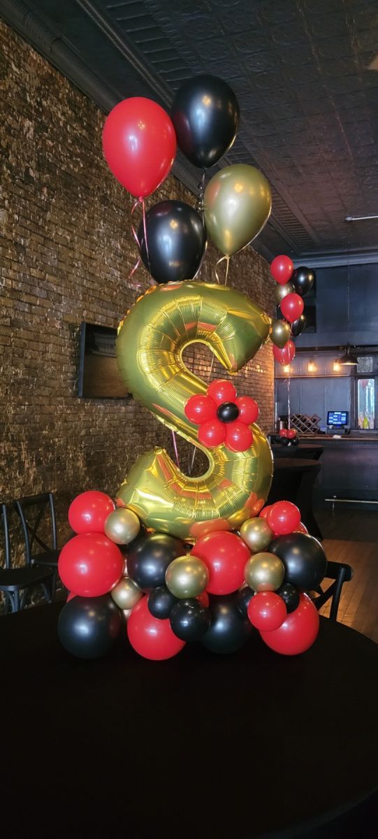 A bunch of balloons are sitting on top of a table. Balloon Marquee