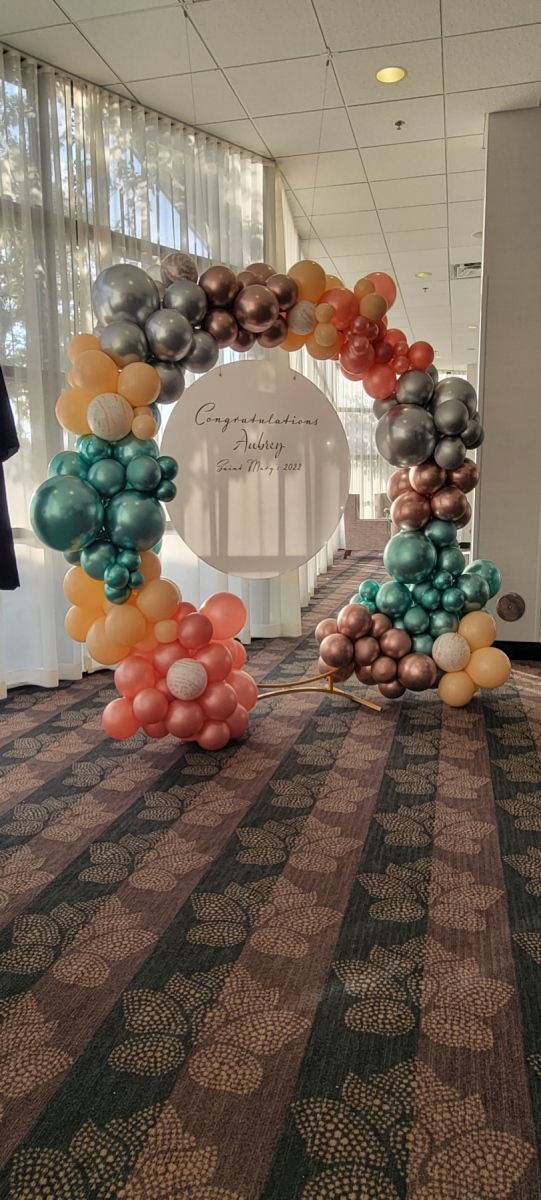 There is a balloon arch in the middle of a room.