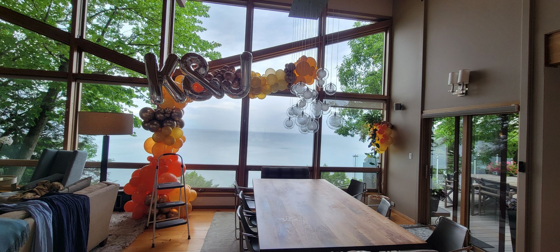 A large room with a long table and balloons hanging from the ceiling.