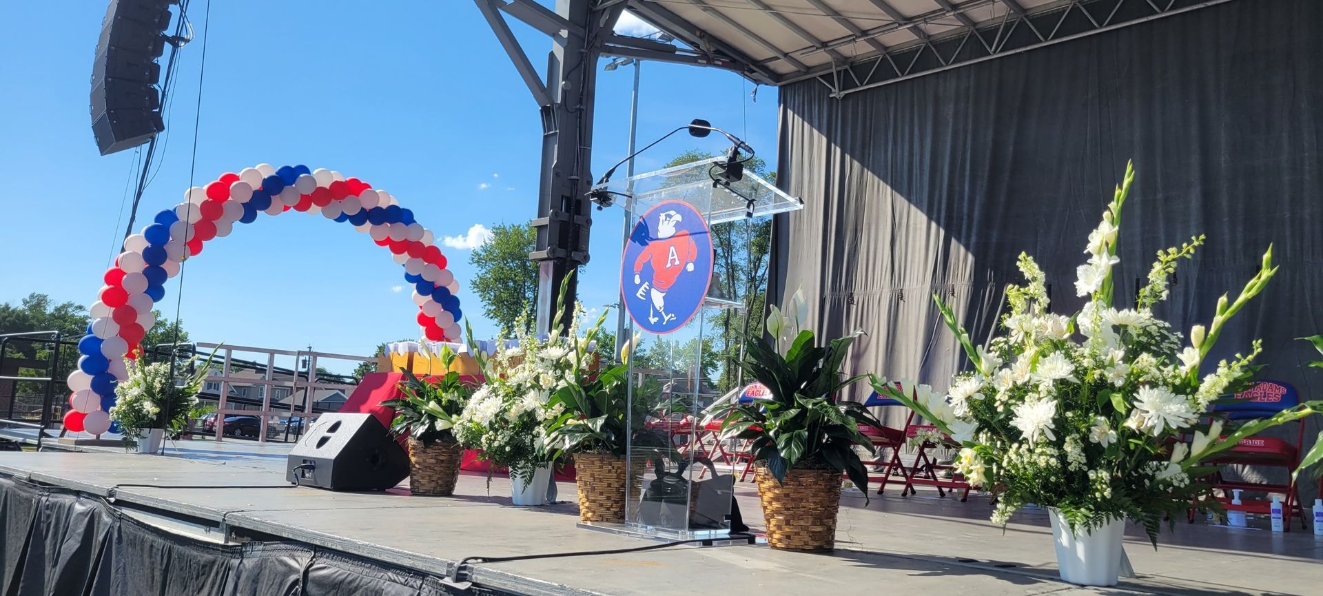 A stage decorated with balloons and flowers for a concert.