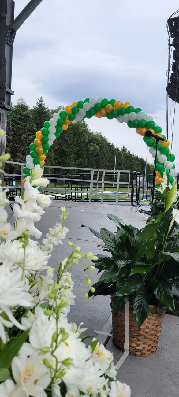A stage decorated with balloons and flowers for a graduation ceremony.