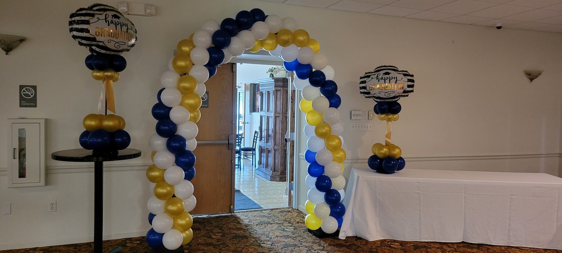 A room decorated with blue , white and gold balloons