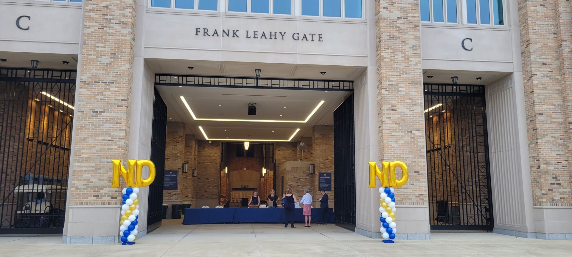 A group of people are standing in front of a building with balloons in front of it.
