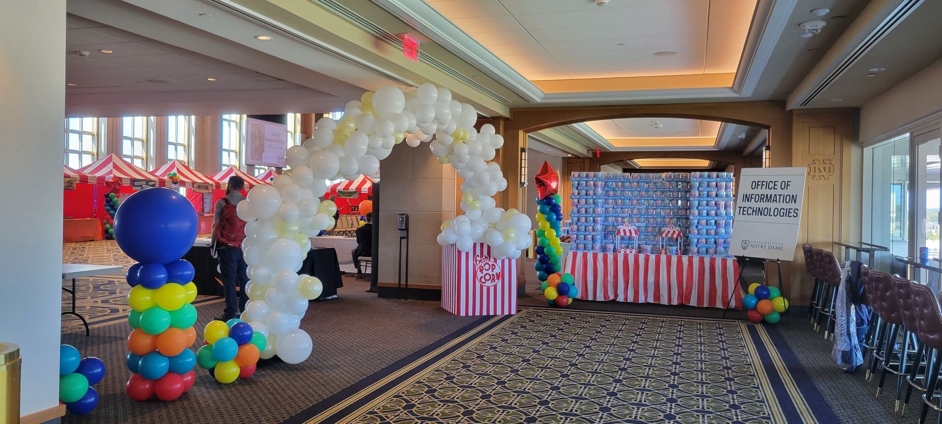 a hallway filled with balloons and a popcorn stand