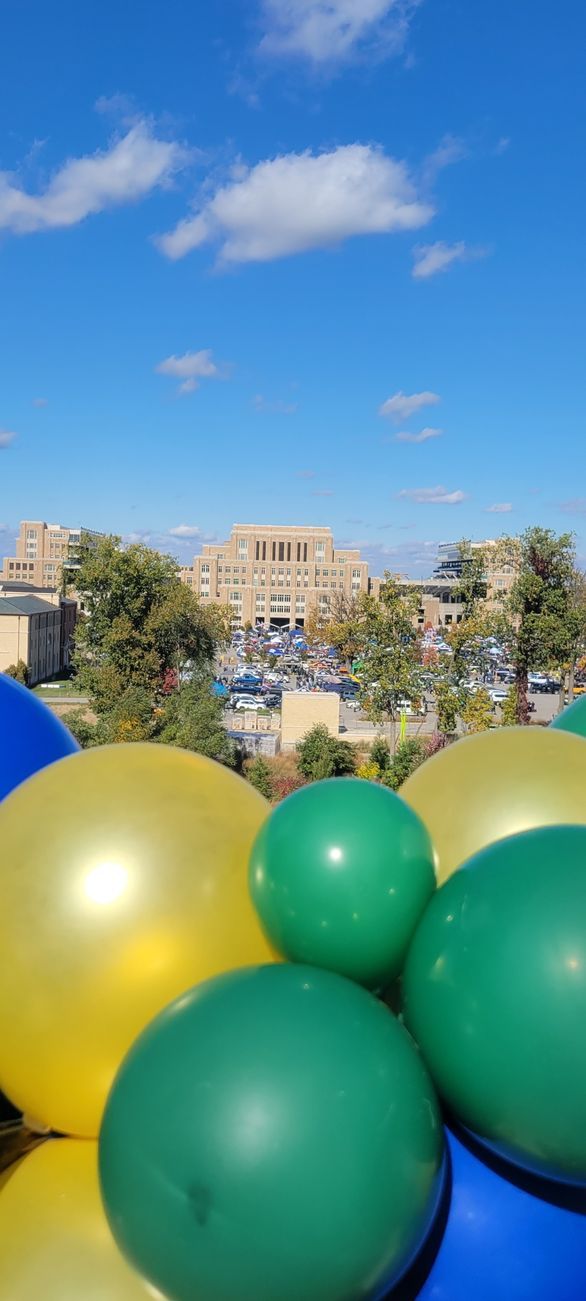 A bunch of balloons are sitting on top of each other in front of a building.
