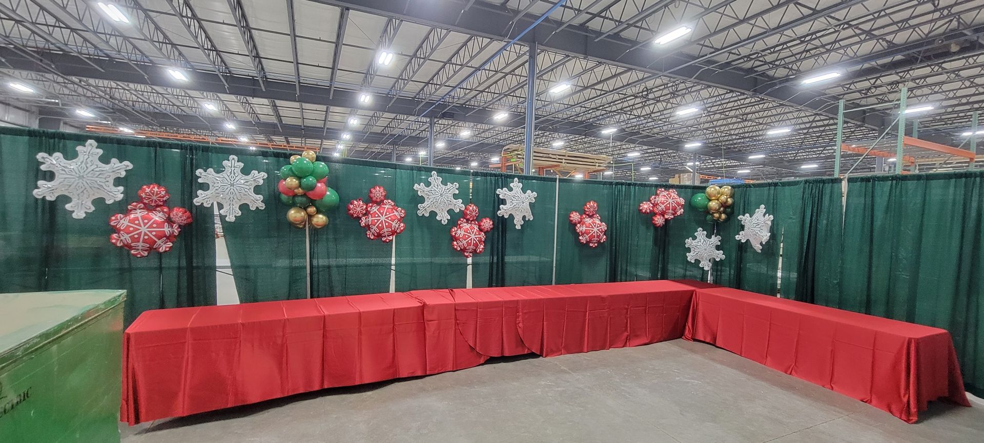 A room with red tables and snowflake balloons on the wall.