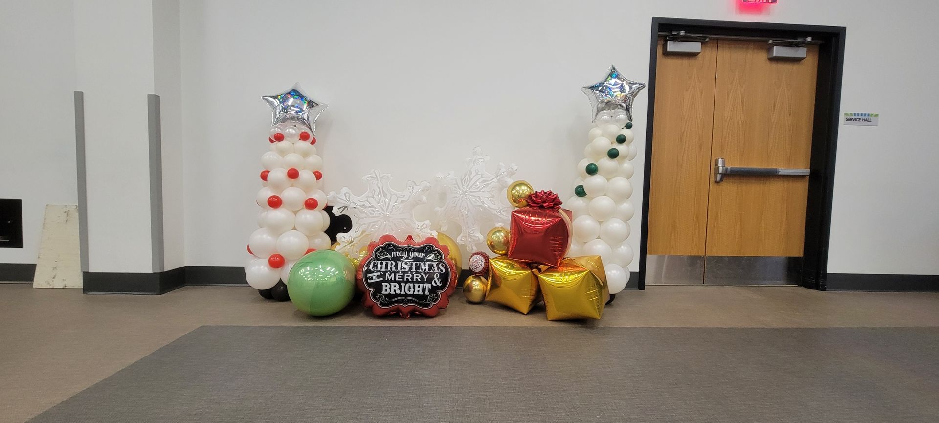 A bunch of balloons are sitting on the floor in a room next to a door.