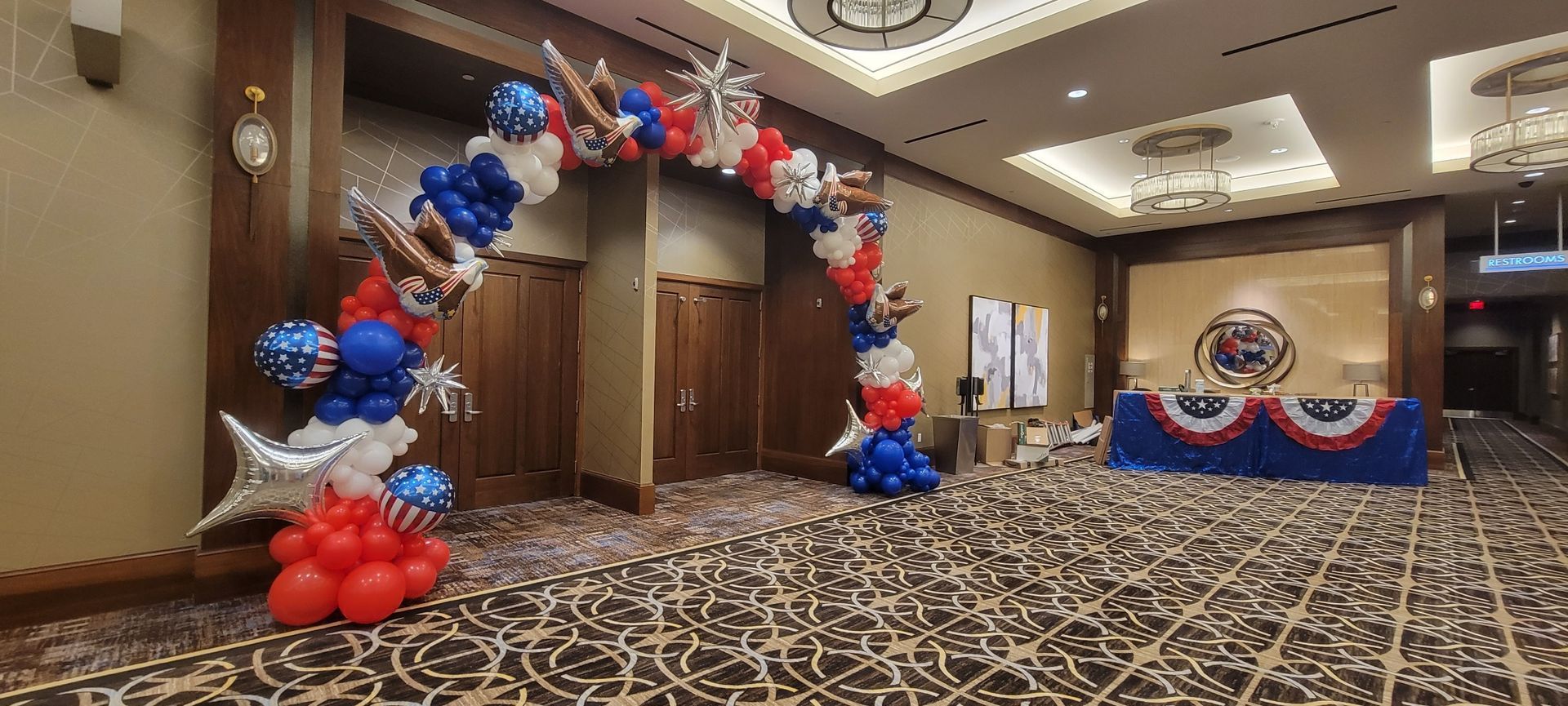 A room decorated with red , white and blue balloons.