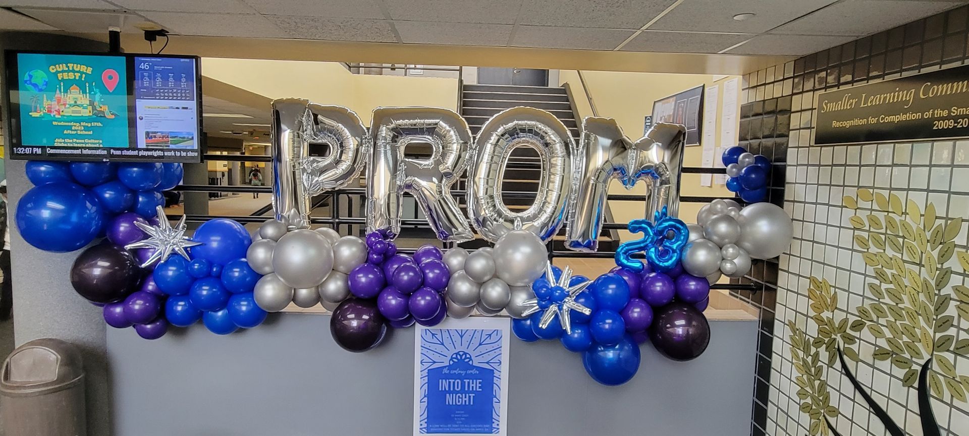 A room decorated with balloons and a sign that says prom.
