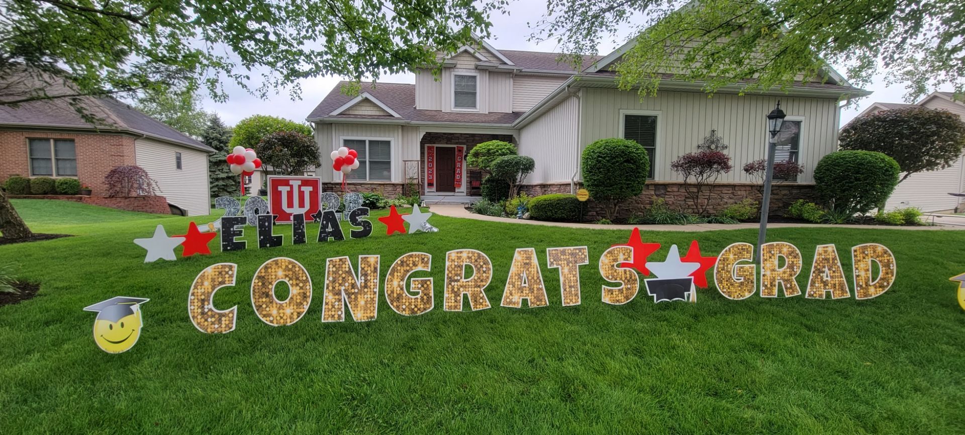 A house with a congratulations grad sign in front of it. Indiana University