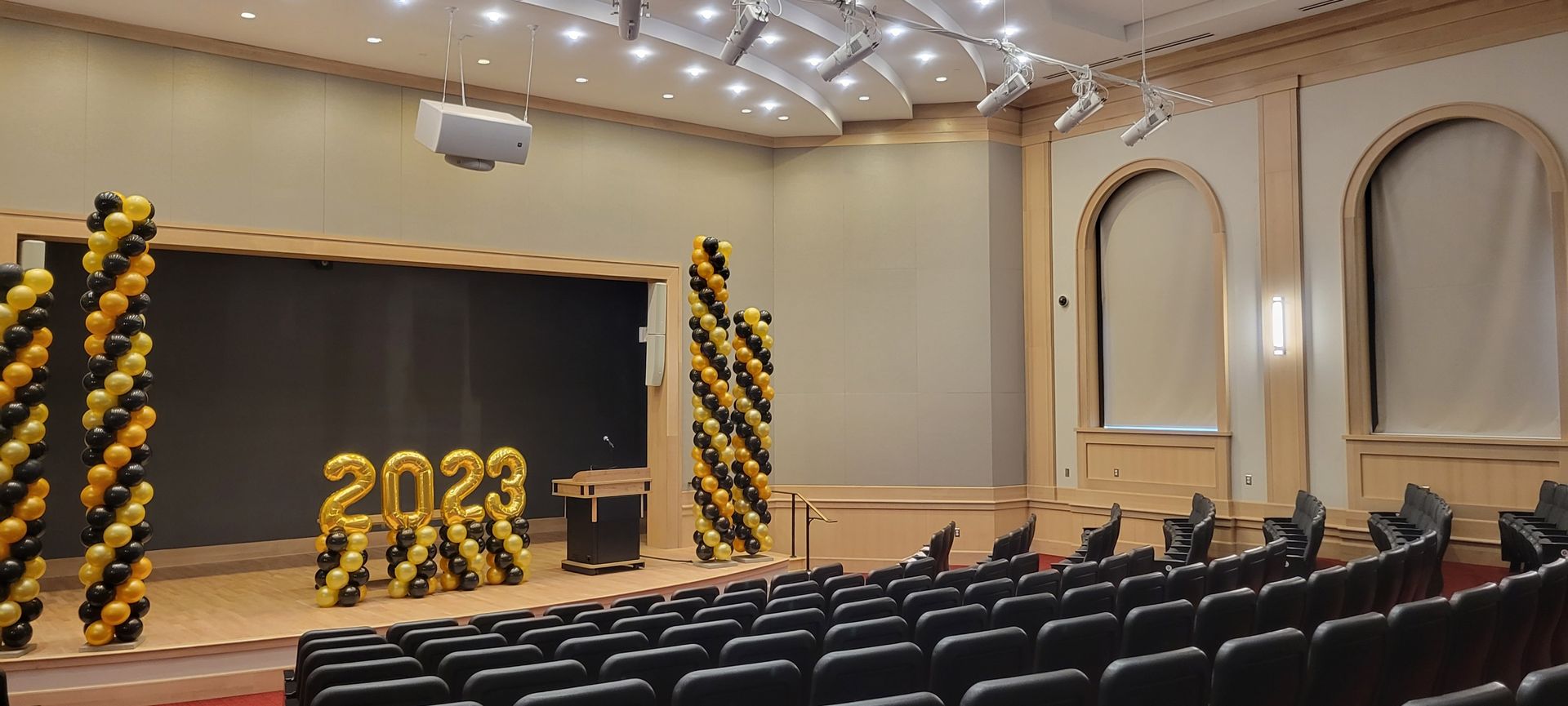 A large auditorium with balloons in the shape of the year 2023