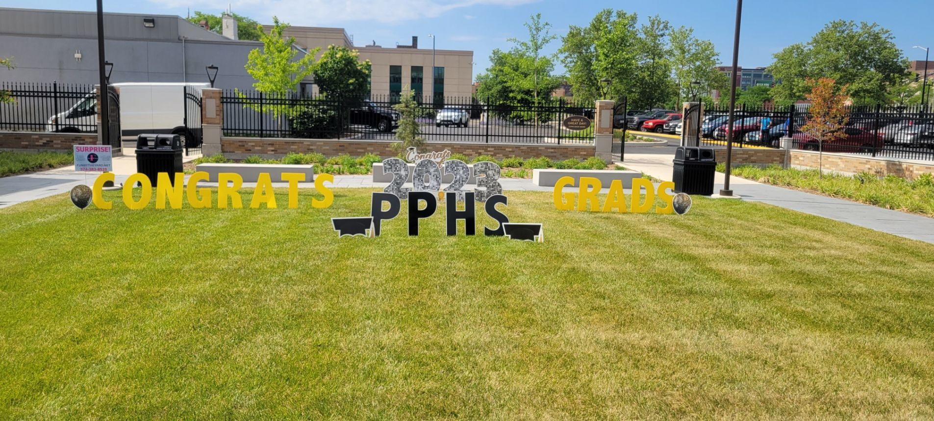 A congratulations sign is sitting on top of a lush green field.