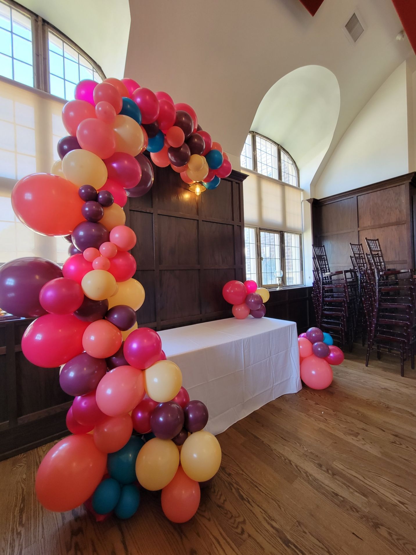 A room with a table and chairs decorated with balloons.