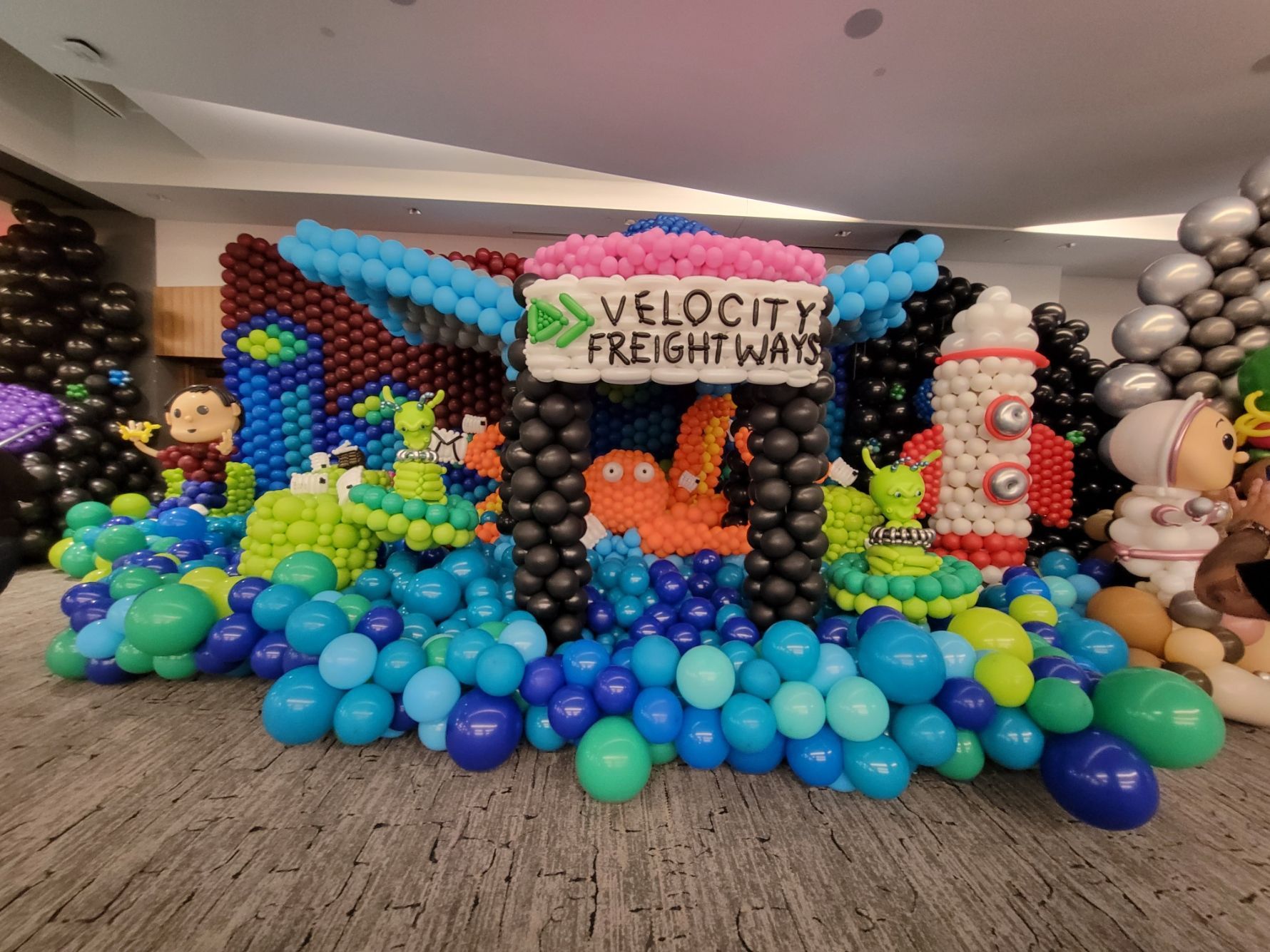 A room filled with balloons and a sign that says velocity freight ways