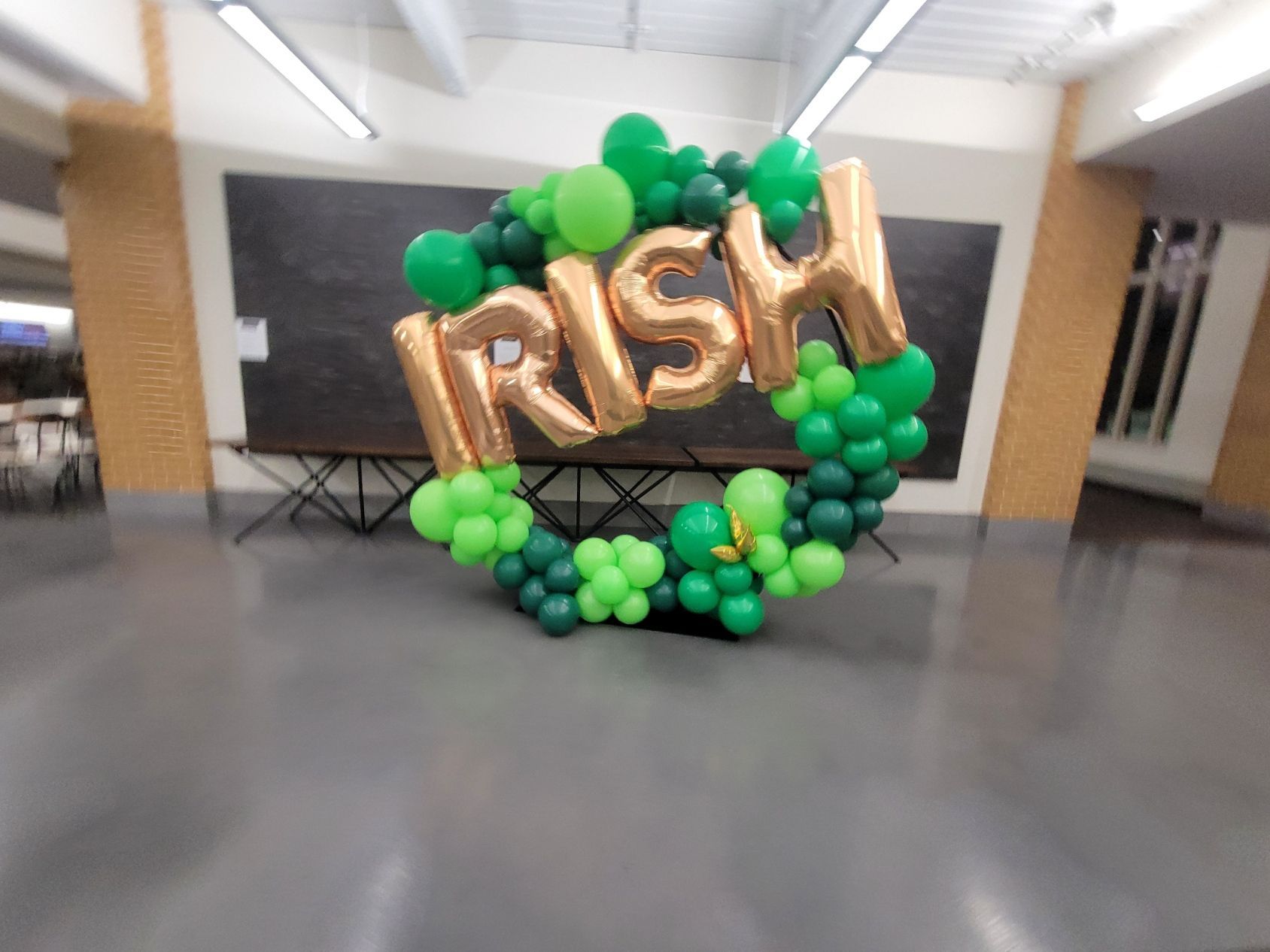 An infinity hoop photo op made of green and gold balloons that says irish