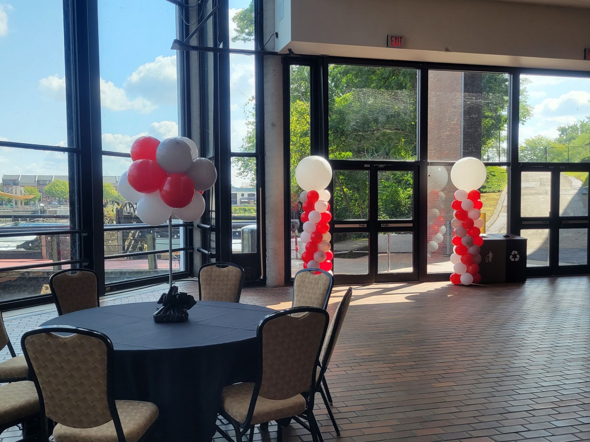 A room with a table and chairs and balloon columns.