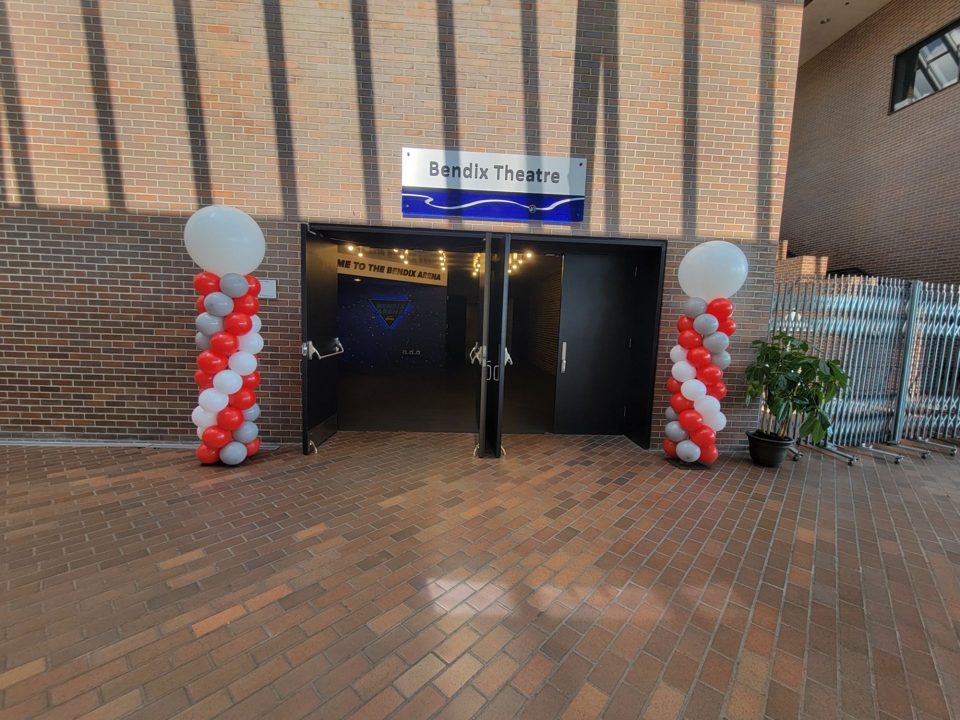 A brick building with balloon columns in front of it