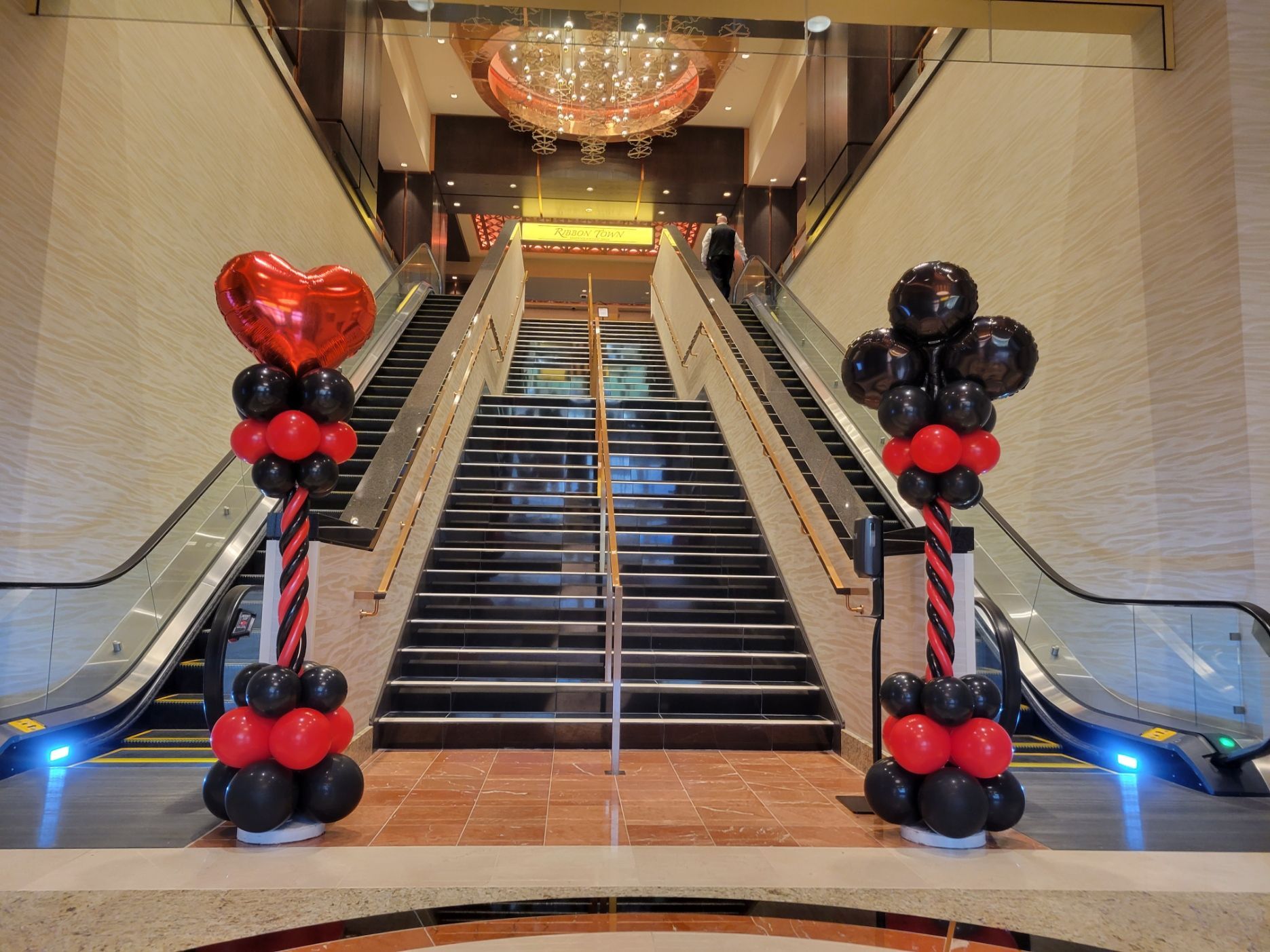 The stairs are decorated with red and black balloons. Casino themed balloons