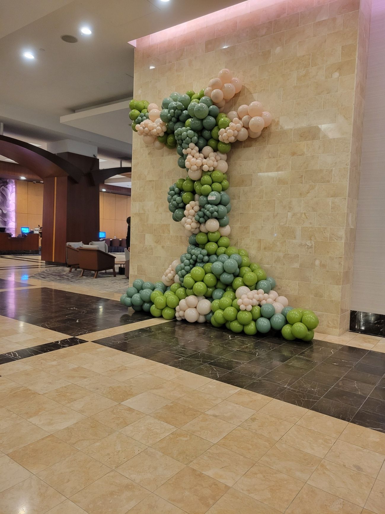 A wall decorated with balloons in the shape of a tree.