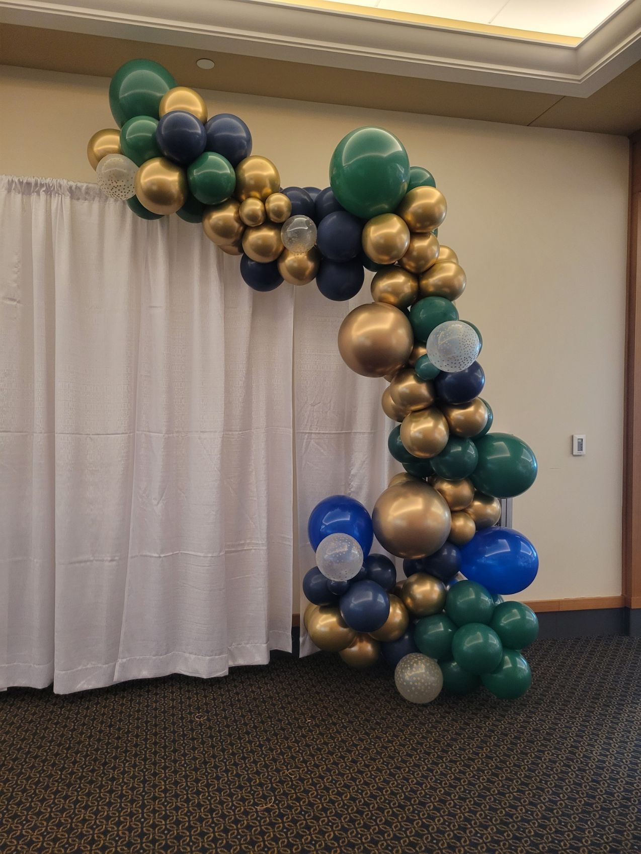 A room filled with balloons and a white curtain.