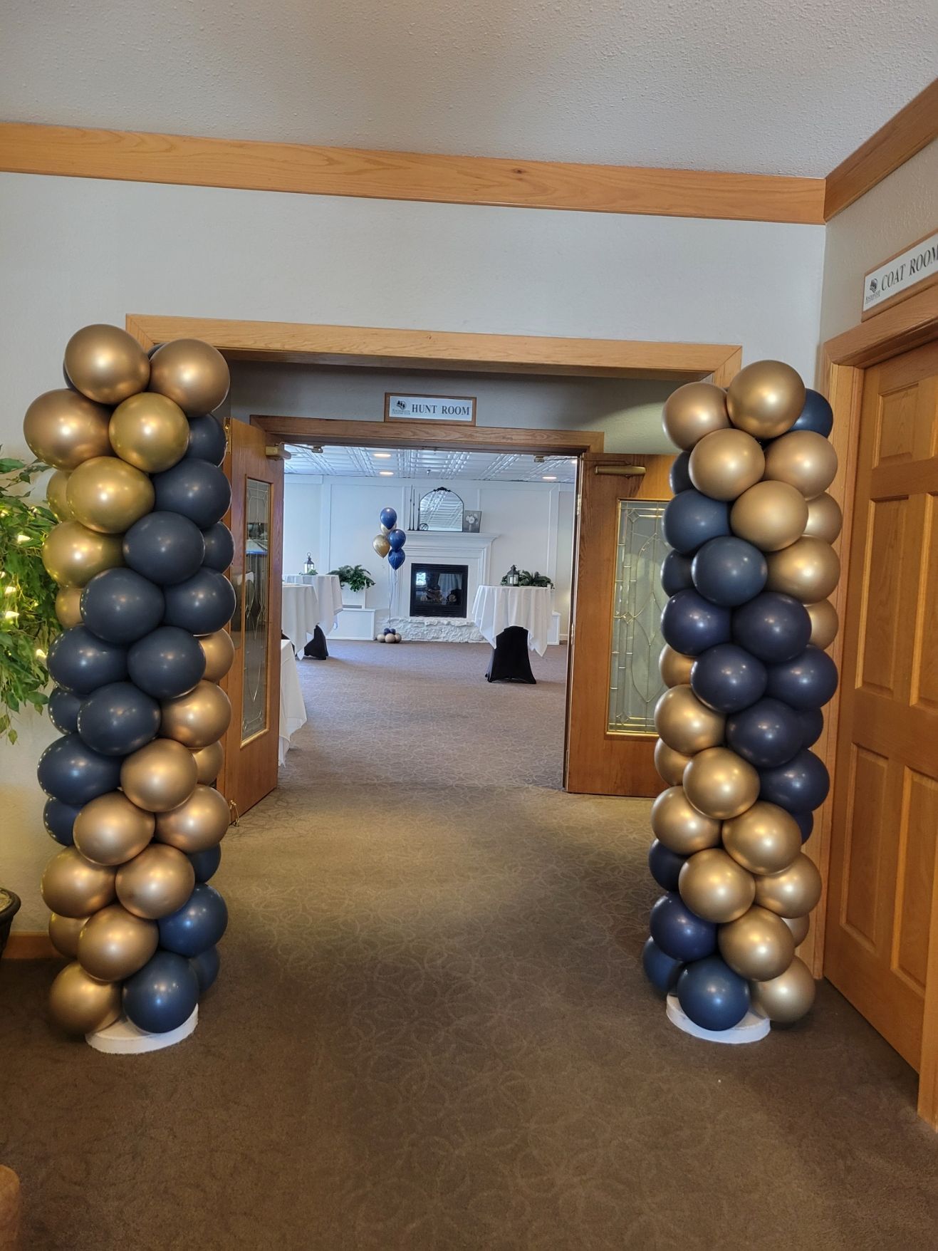 A hallway filled with blue and gold balloons.