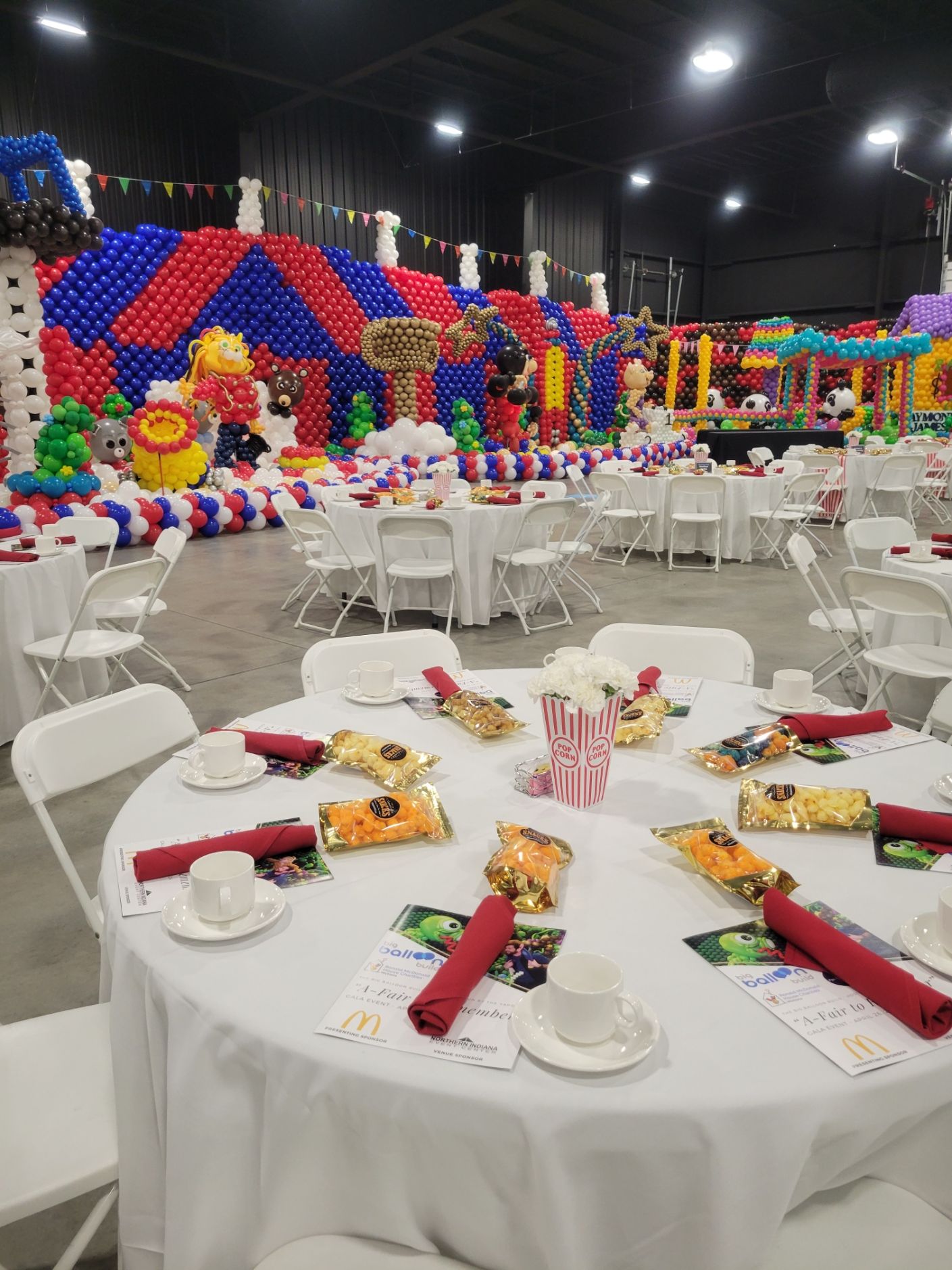 A large room filled with tables and chairs set up for a party.