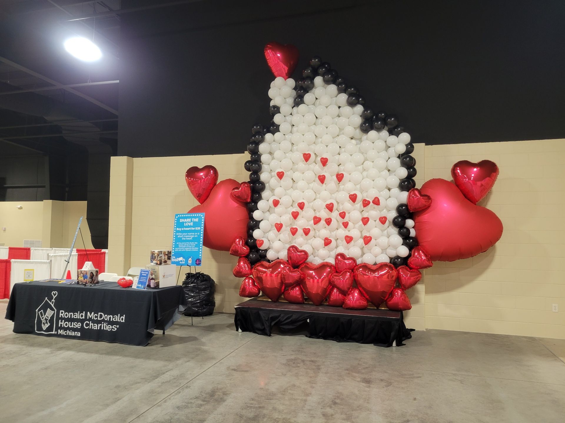 A wall made of balloons and hearts in the shape of a house