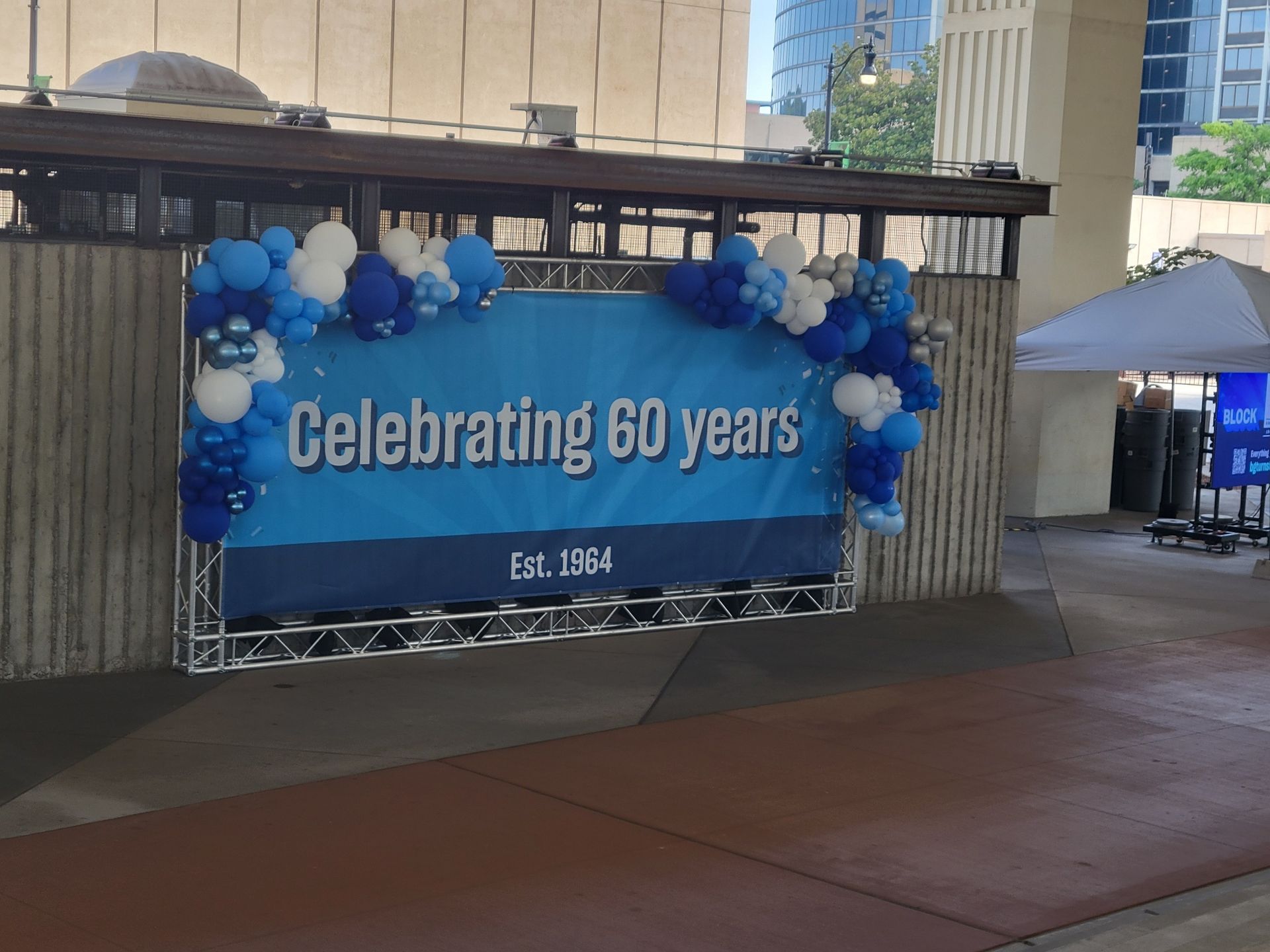 A sign that says celebrating 60 years is surrounded by blue and white balloons