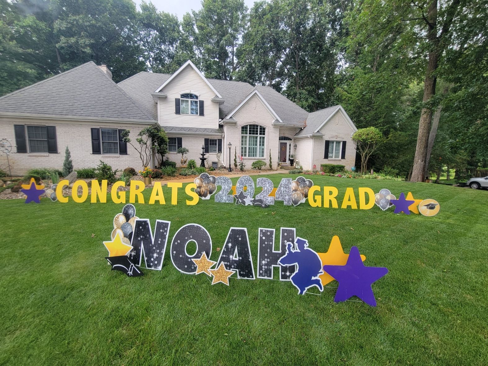 A large house with a congratulations sign in front of it.
