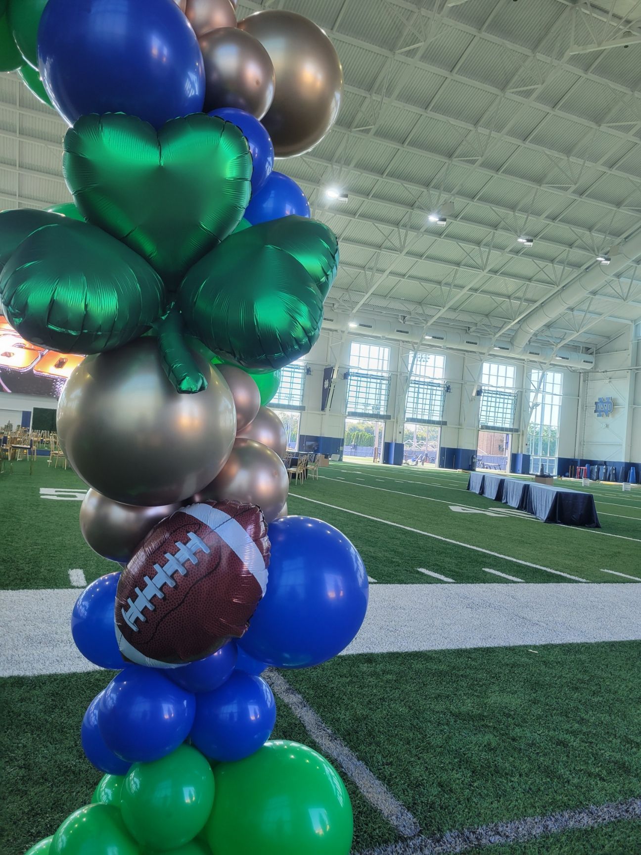 A bunch of balloons are stacked on top of each other on a football field.